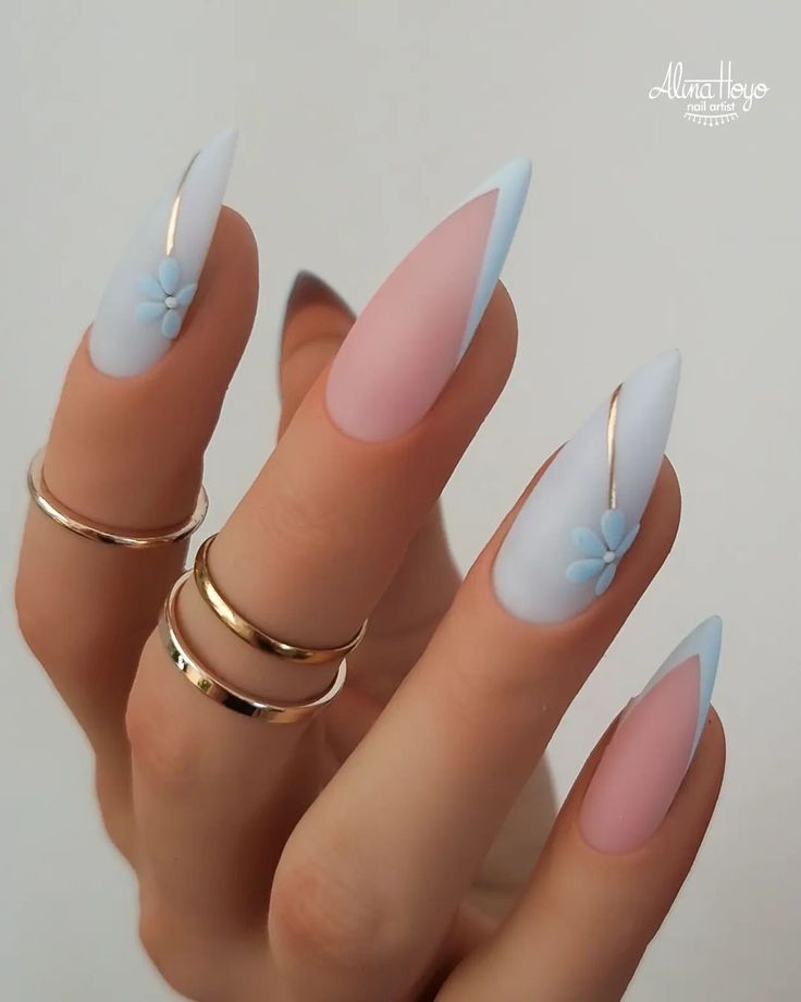 Chic Pastel Almond Nail Design with Floral Accents and Gold Rings.