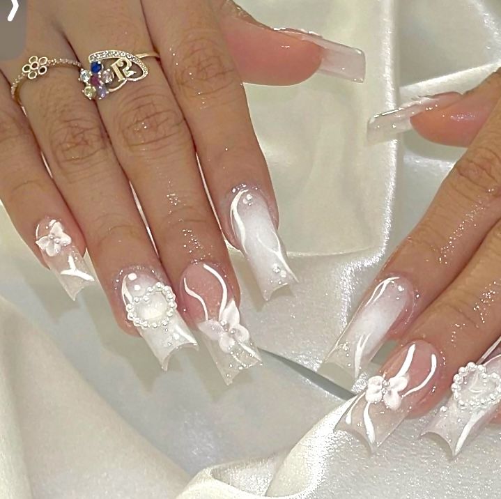 Sophisticated Ombre Acrylic Nail Design with Floral Embellishments and Sparkle.