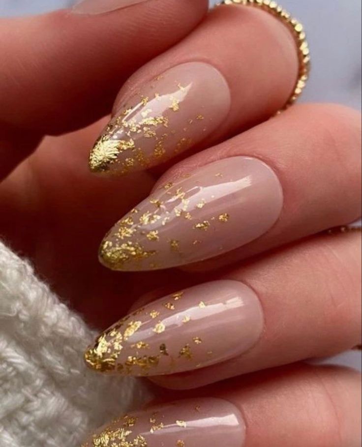 Elegant Nude Nail Design with Glamorous Gold Flakes for Any Occasion.