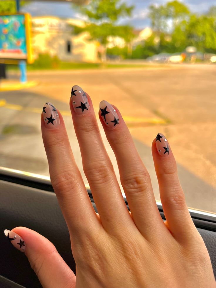 Elegant Starry French Manicure: Chic Nude Base with Playful Black Tips and Star Accents.