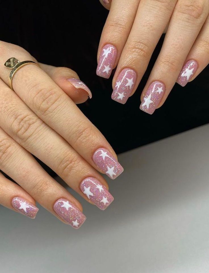 Dreamy Soft Pink Nail Design with Glitter and Whimsical White Stars