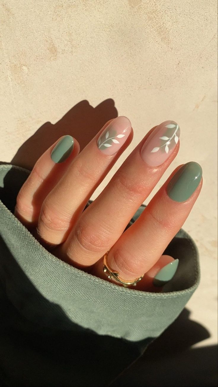 Sophisticated Nail Design: Muted Green and Soft Beige with Delicate Leaf Patterns.