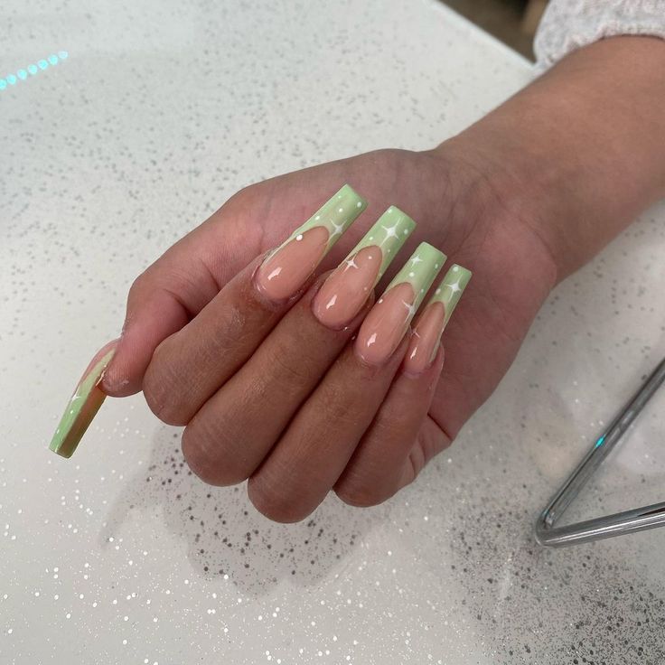 Whimsical Pastel Nail Design with Elongated Tips in Soft Peach and Light Green.