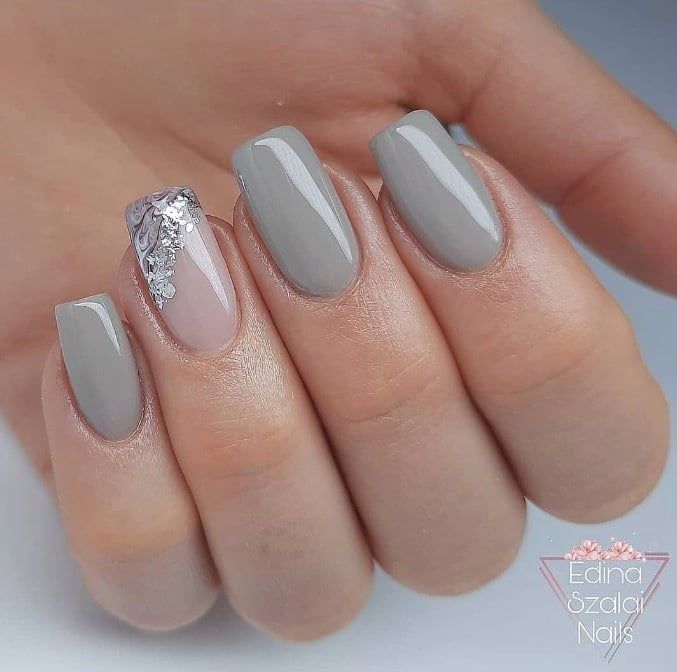 Chic Grey Nail Design with Glossy Finish and Intricate Embellishments for Modern Elegance.