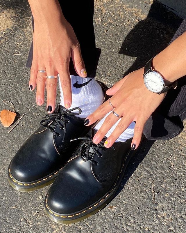 Chic Black Nail Design Enhanced by Metallic Accents and Trendy Footwear.