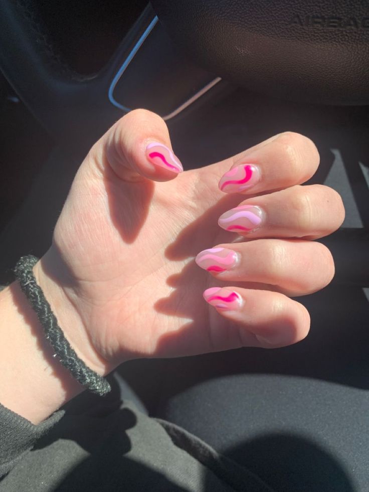 Trendy Pink Ombre Nails with Playful Wavy Designs for a Stylish Look.