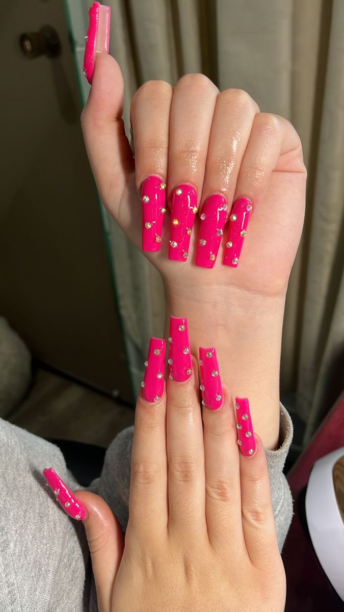 Glamorous Vibrant Pink Stiletto Nails with Shimmering Rhinestones.