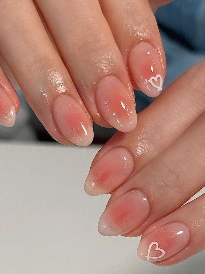 Delicate Ombre Nail Design with Heart Motifs for a Romantic Touch.