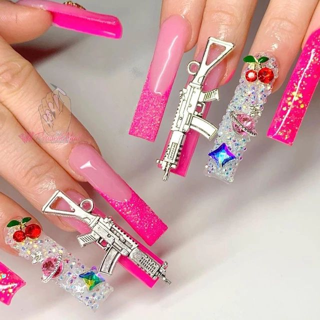 Vibrant Pink Tip Nail Design with Edgy Charms and Glitter Accents for a Striking Look.