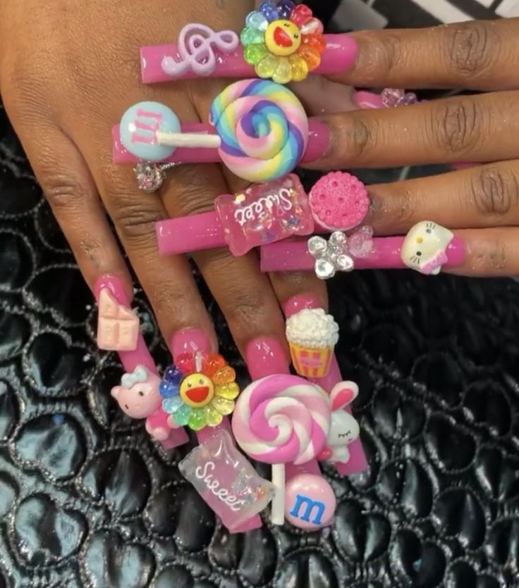 Vibrant Candy-Themed Nail Art with Whimsical Charms and a Glossy Pink Base.