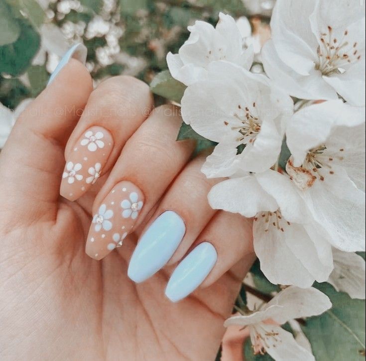 Charming Floral-Inspired Nail Design in Pastel Blue and Nude for a Fresh Spring Aesthetic.