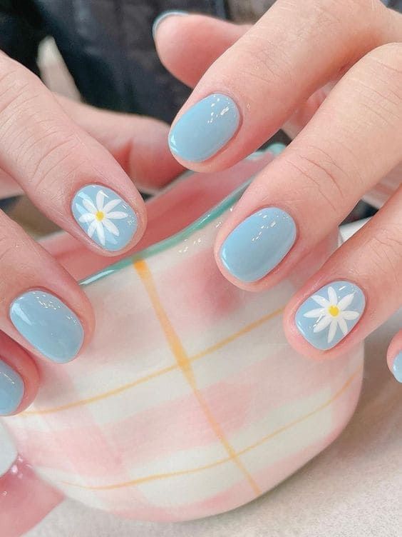 Charming Spring-Inspired Blue Nail Design with Daisy Accents.