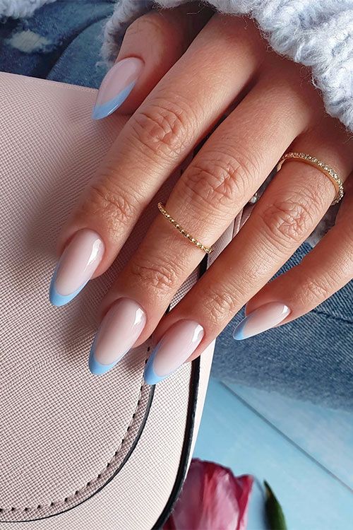 Chic Almond-Shaped Ombre Nails with Blue French Tips and Minimalist Gold Rings.