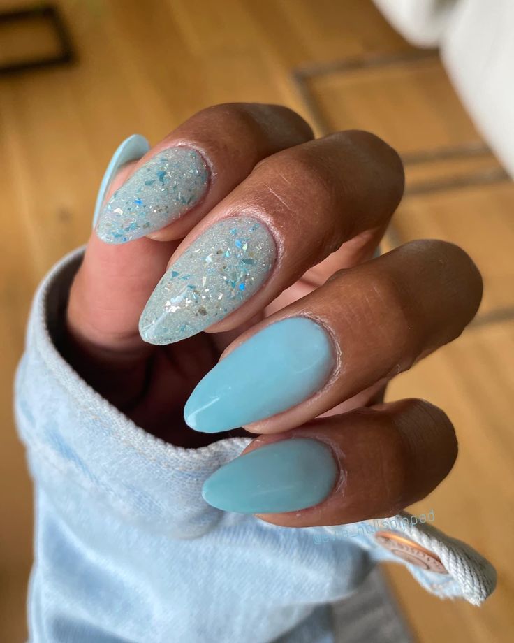 Elegant Almond-Shaped Pastel Blue Nail Design with Glitter Accents.