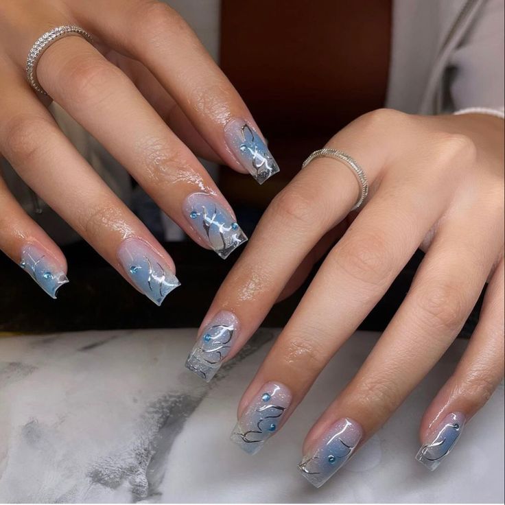 Elegant Frosted Blue and Clear Nail Design with Silver Swirls