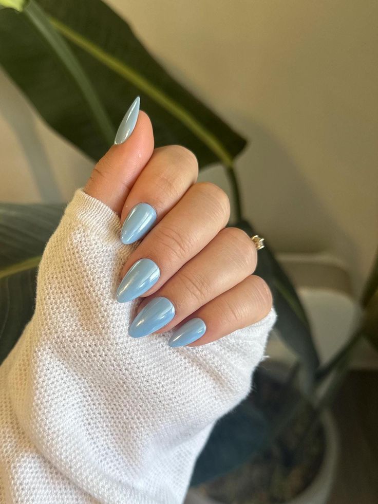 Stylish Stiletto Light Blue Nails: A Chic Contrast to Cozy White Sweater.