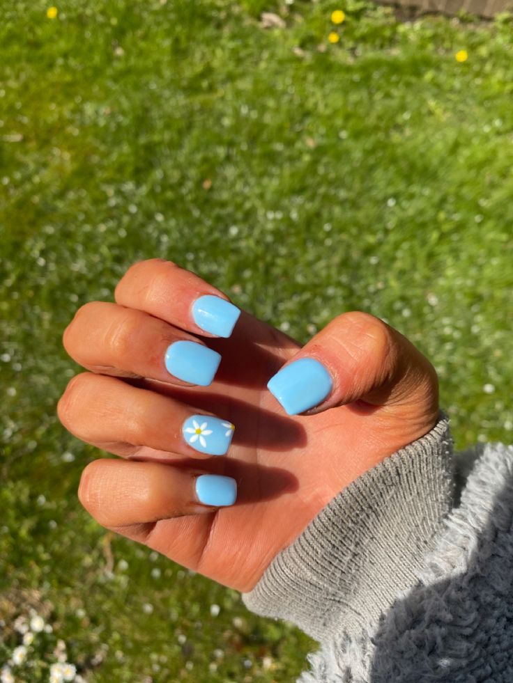 Charming Soft Blue Manicure with Glossy Finish and Floral Accent for Spring/Summer.