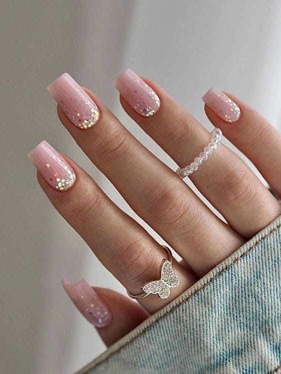 Sophisticated Soft Pink Ombre Nail Design with Glitter and Delicate Rings