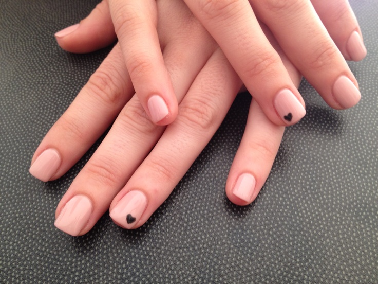 Chic Minimalist Nude Nail Design with Black Heart Accents.