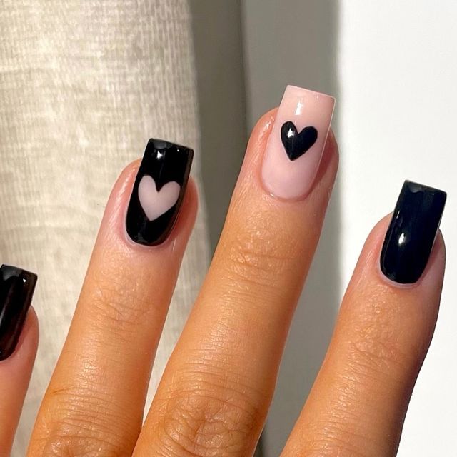 Chic Heart-Themed Nail Design: Glossy Black and Soft Pink Elegance with Playful Whimsy.