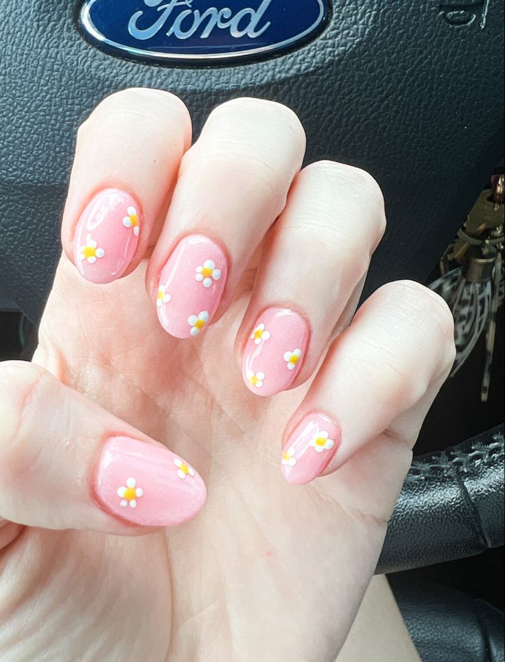 Whimsical Pink Nail Design with Cheerful Daisy Accents for Spring and Summer.