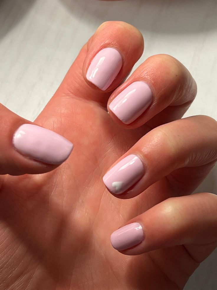 Elegant Soft Pink Nails with Whimsical Heart Design for a Charming Look.