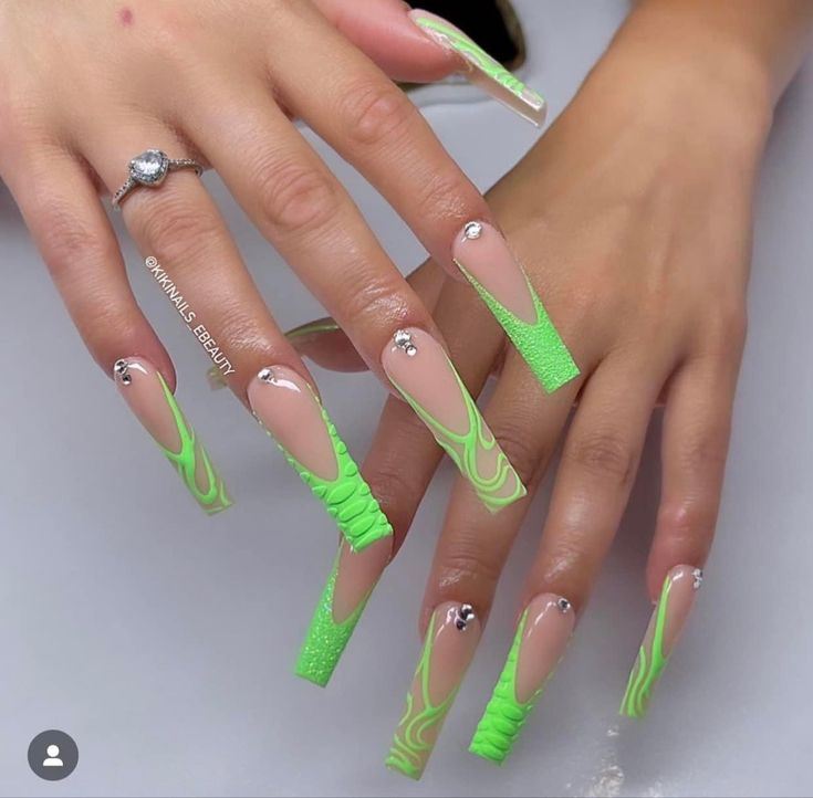 Vibrant Green Stiletto Nails with Glossy and Matte Finishes, Intricate Swirls, and Sparkling Rhinestones.