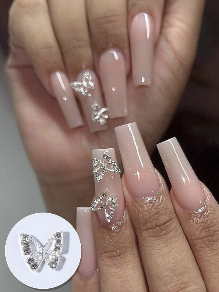 Elegant Butterfly Nail Design on Soft Nude Base with Sparkling Decorations.