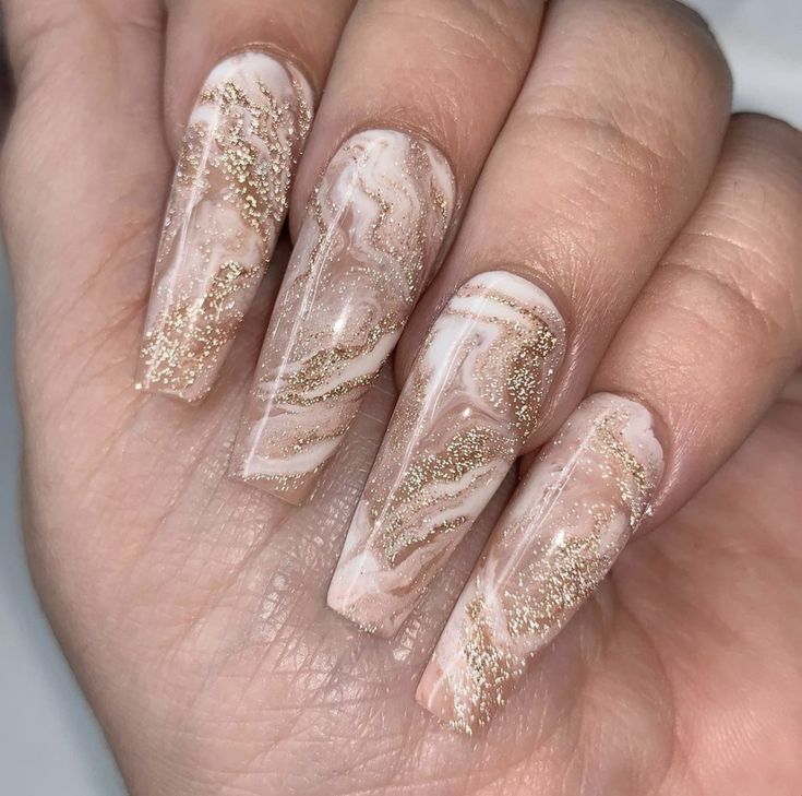 Stunning Marbled Nude Nails with Elegant Gold Accents and Glamorous Glitter