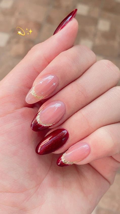 Sophisticated Deep Red and Nude Nail Design with Glossy Finish and Gold Accents.