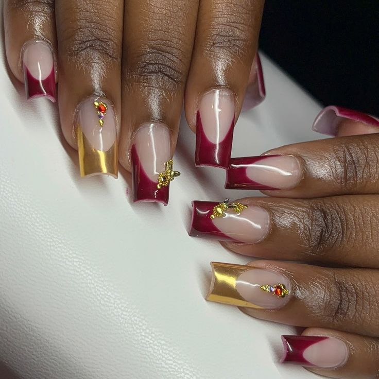 Luxurious Burgundy and Nude Nail Design with Gold Foil Accents