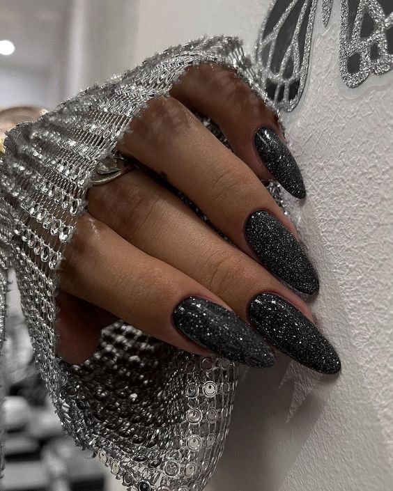 Sophisticated Almond-Shaped Black Glitter Nails for Glamorous Occasions.