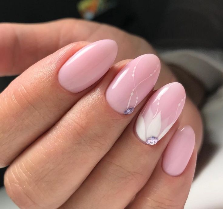 Sophisticated Soft Pink Nail Design with Elegant Floral Accents and Shimmering Gems.