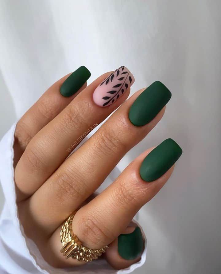 Chic Matte Green and Soft Pink Nail Design with Intricate Black Leaf Accent.