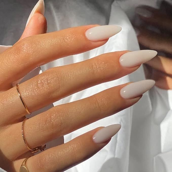 Chic Almond-Shaped Nails in Soft Beige with Gold Accents for a Sophisticated Look.