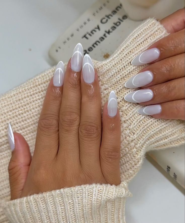 Chic Almond-Shaped Nail Design: Glossy White and Negative Space Aesthetic