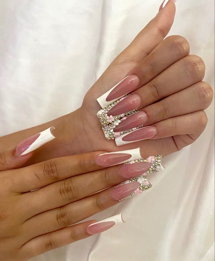 Chic Soft Pink and White Nail Design with Glamorous Embellishments for Special Occasions.