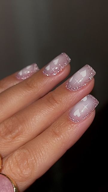 Charming Soft Pink Nail Design with White Hearts and Sparkling Gradients for Romantic Elegance.