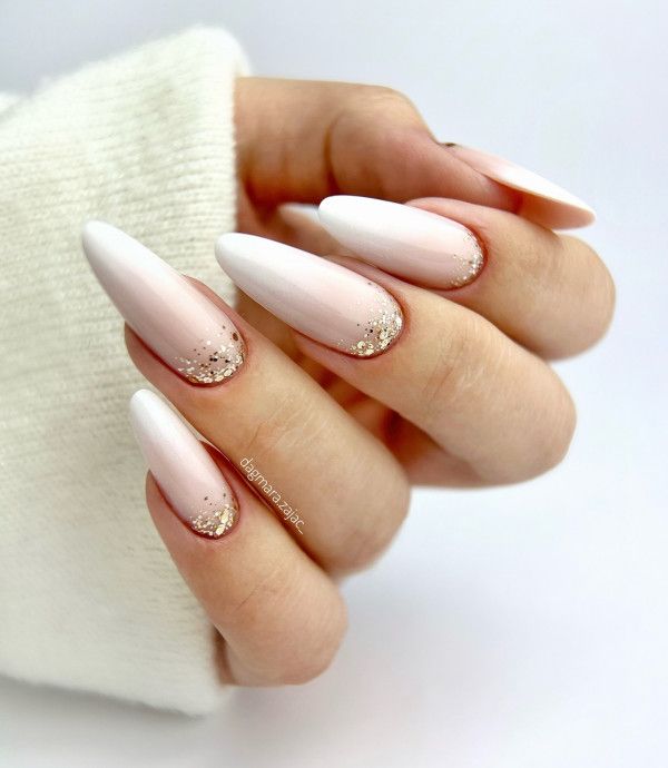 Chic Ombre Nail Design: Soft White and Blush with Gold Glitter Accents.