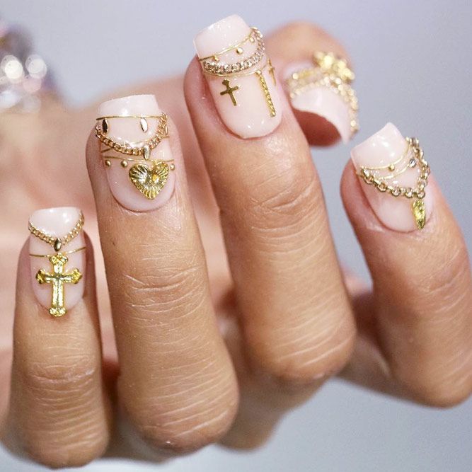 Elegant Nude Nail Design with Intricate Gold Accents and Spiritual Motifs.