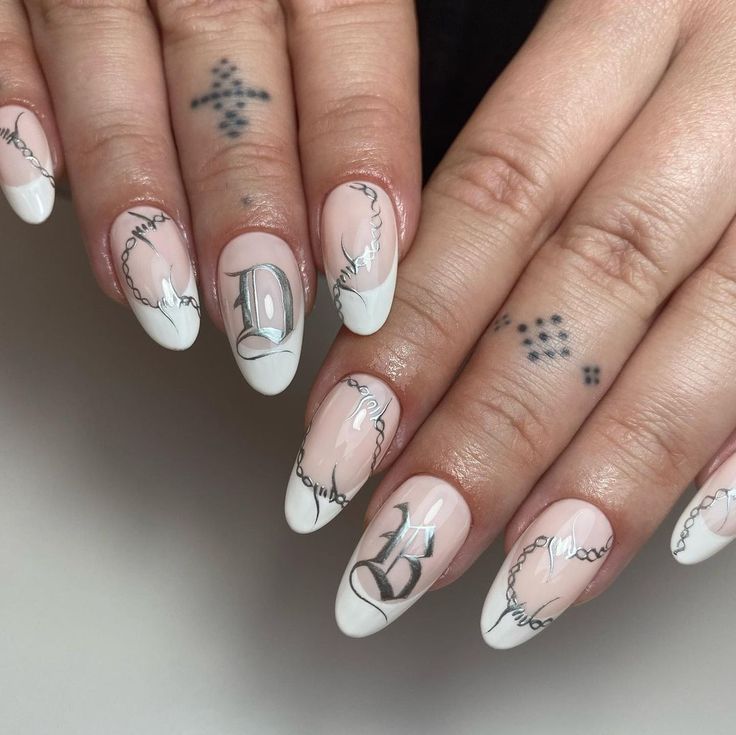 Chic French Tip Nail Design with Intricate Chains and Bold Center Lettering.