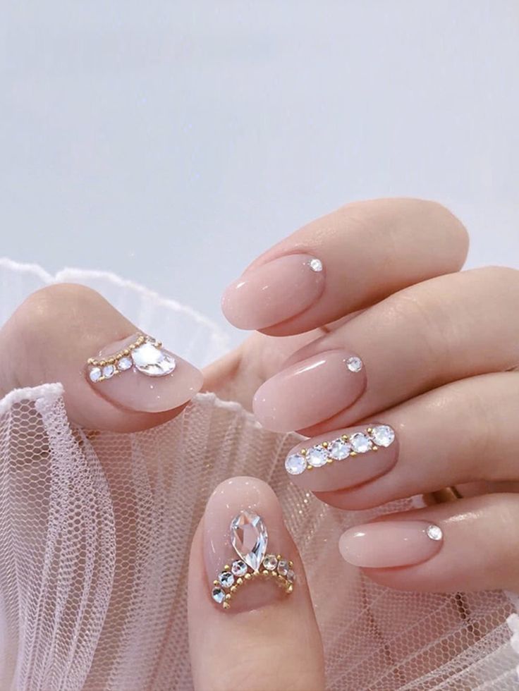 Chic and Sophisticated Nude Nail Design Adorned with Shimmering Rhinestones.