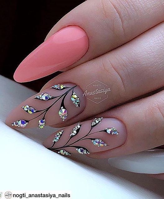 Sophisticated Nail Design: Soft Pink and Nude with Glamorous Black Branches and Sparkling Rhinestones.