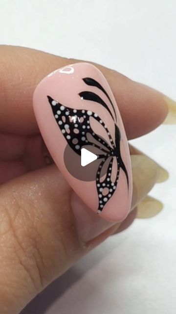 Chic Nail Design with Delicate Butterfly Motif on Soft Pink Background.