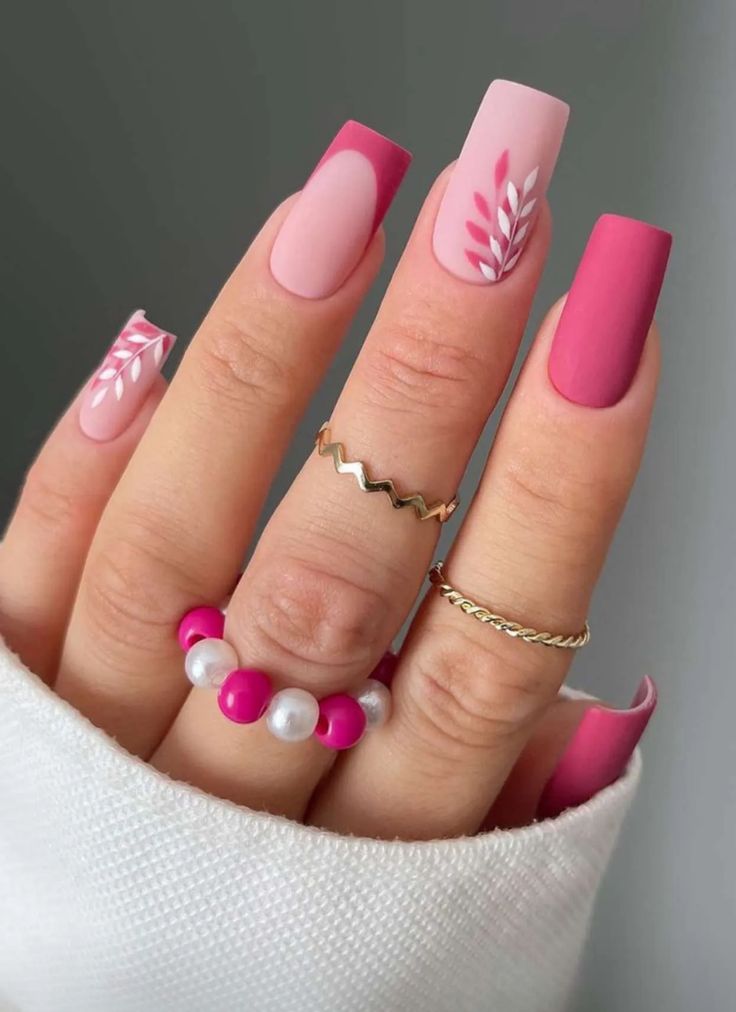 Elegant Pink and Nude Nail Design with Floral Accents and Chic Accessories.