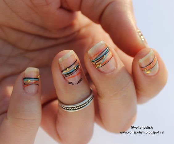 Modern Nail Design: Elegant Nude Base with Vibrant Geometric Patterns and Delicate Embellishments.