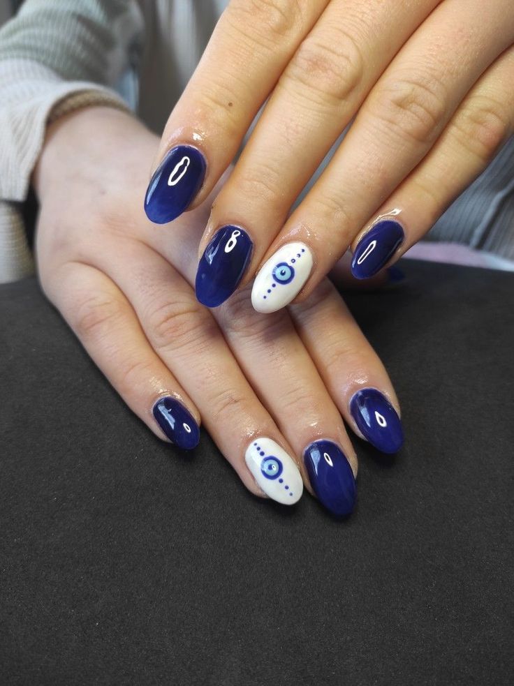 Sophisticated Deep Blue Nail Design with Playful Eye Motif Accent.