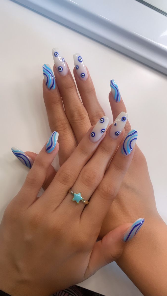 Elegant Wavy Nail Design: Soft White and Blue Hues with Playful Eye Motifs.