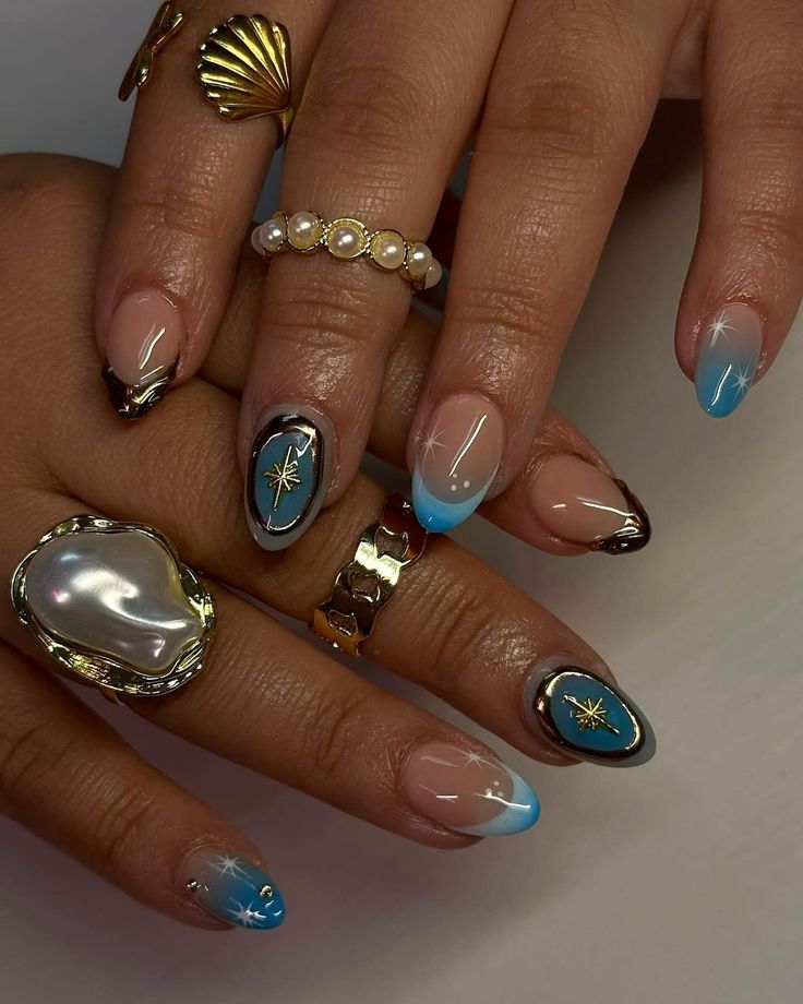 Elegant Gradient Blue Nail Art with Metallic Accents and Chic Designs.