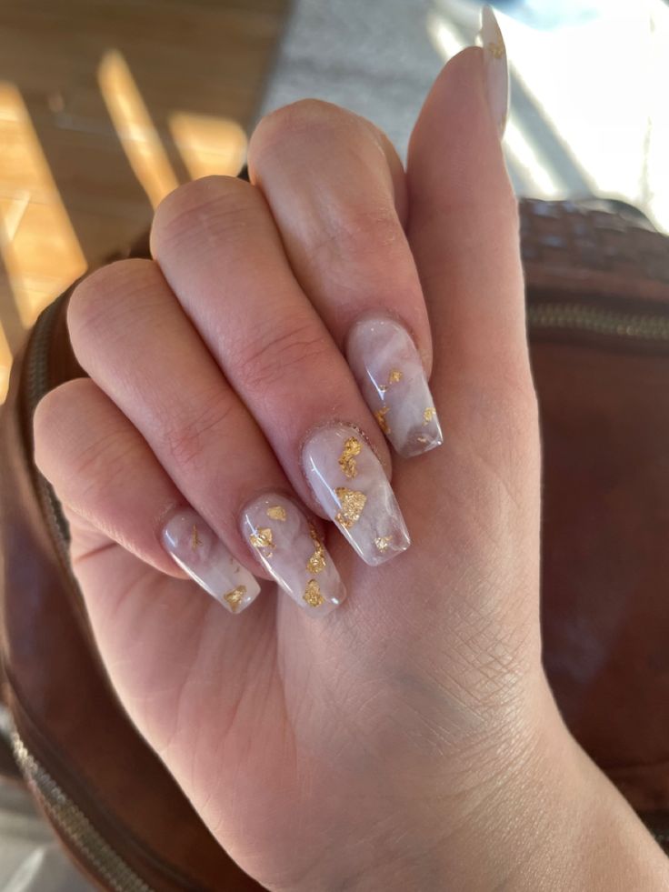 Luxurious Marble-Effect Nail Design with Translucent Base and Gold Flakes